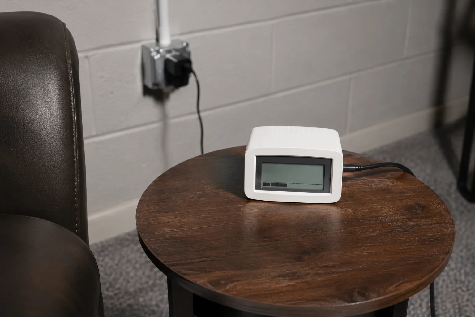 Continuous radon monitor placed on a side table in a finished basement